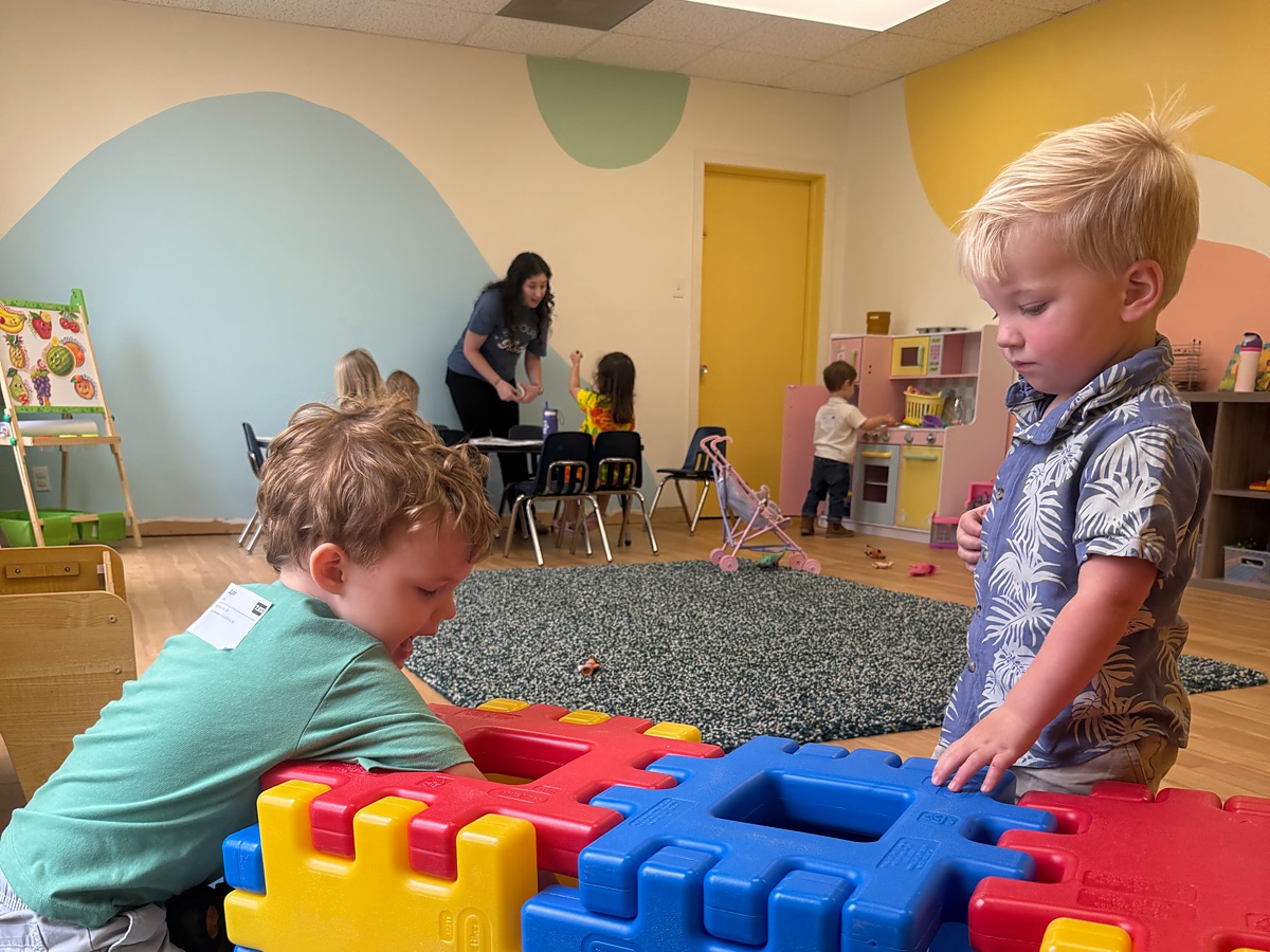 Two boys building with big colorful blocks in the 2s and 3s classroom
